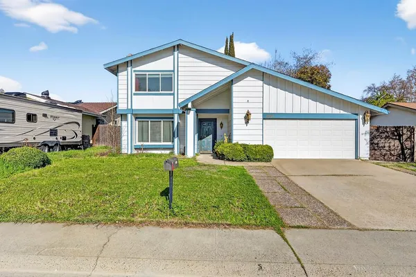 a front view of a house with a garden and plants
