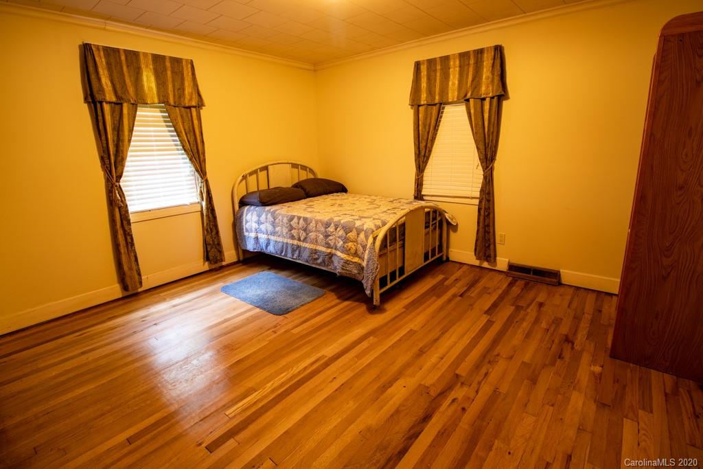 1271 Upper Brush Creek Road Fairview, NC 28730 - Photo 14 of 19 a bedroom with a bed and wooden floor