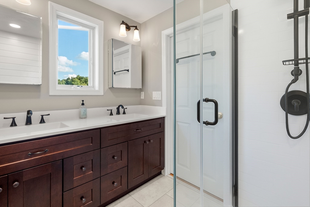 216 Old Littleton Road Harvard, MA 01451 - Photo 20 of 34 a bathroom with a double vanity sink a mirror and a shower