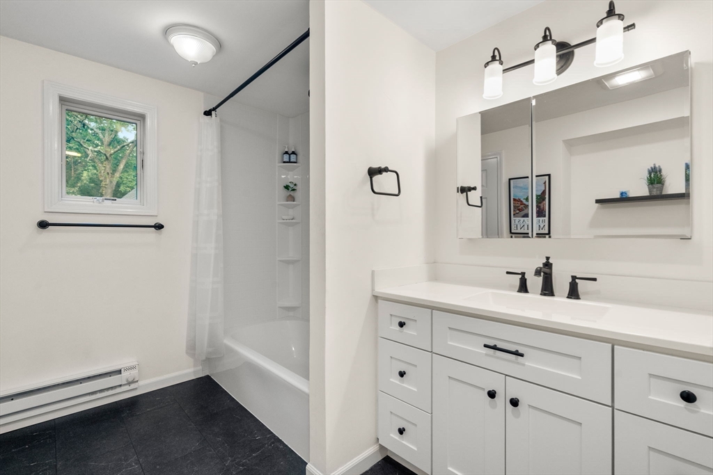 216 Old Littleton Road Harvard, MA 01451 - Photo 24 of 34 a bathroom with a double vanity sink a mirror and a bathtub
