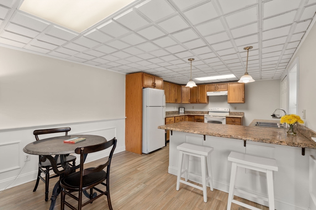 216 Old Littleton Road Harvard, MA 01451 - Photo 28 of 34 a kitchen with a table chairs and a refrigerator