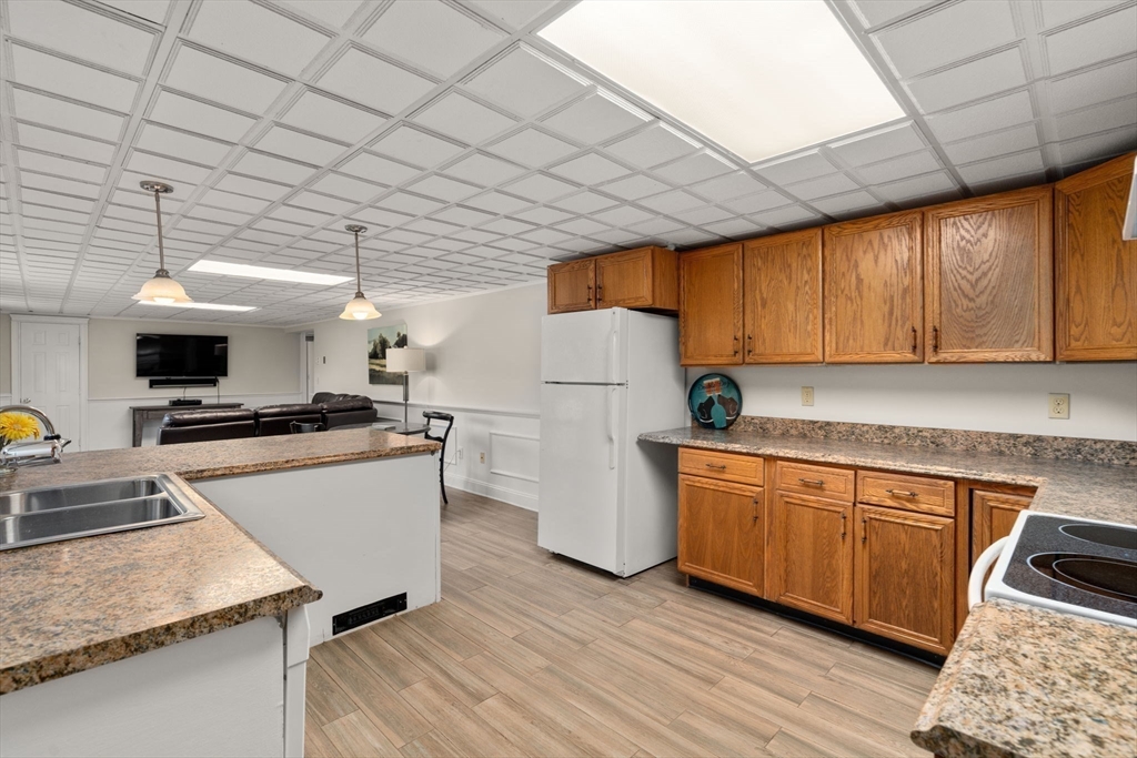 216 Old Littleton Road Harvard, MA 01451 - Photo 29 of 34 a kitchen with stainless steel appliances granite countertop a refrigerator a sink dishwasher a stove and white countertops with wooden floor