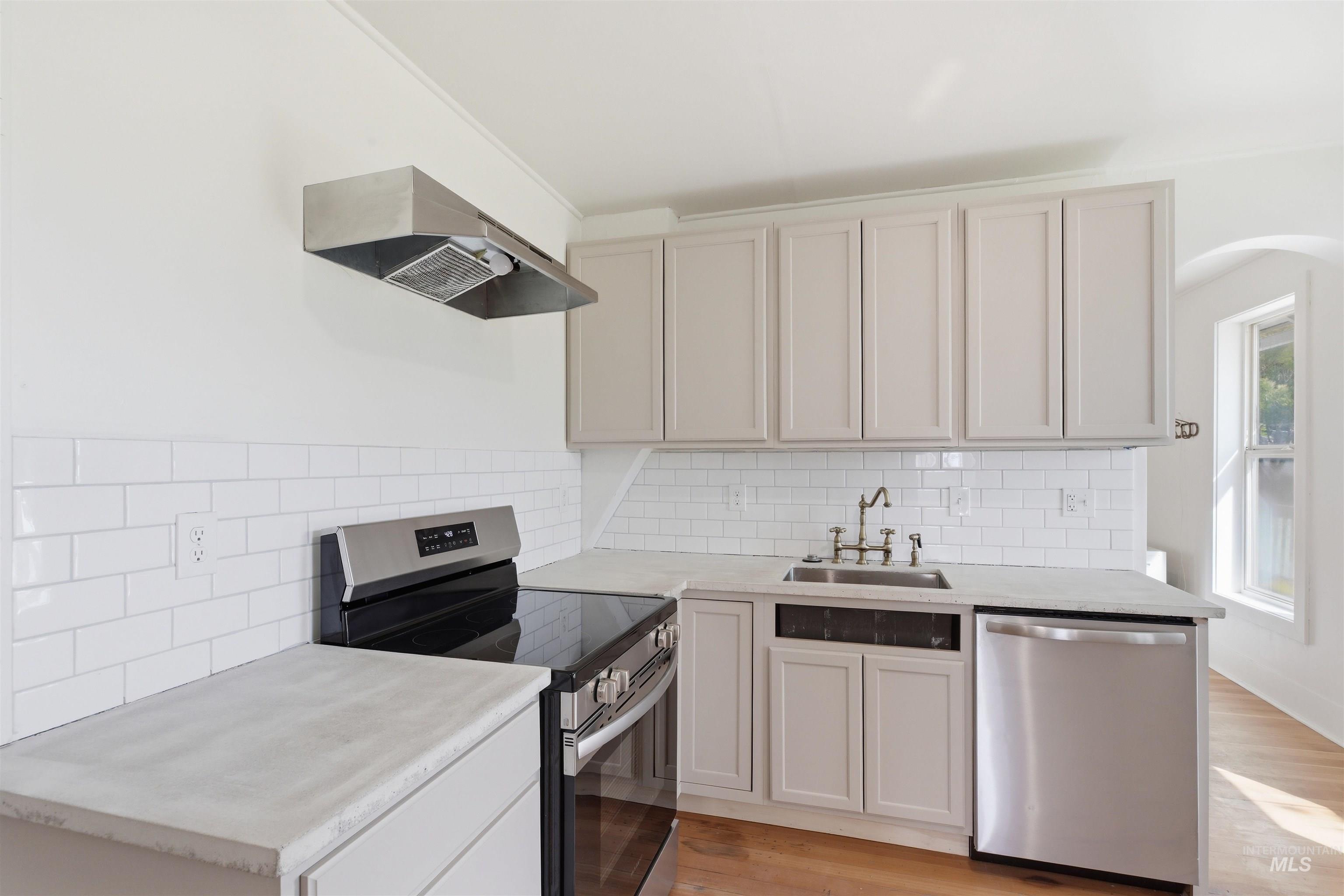 810 Pine Street Potlatch, ID 83855 - Photo 11 of 33 Kitchen featuring light gray cabinetry, white subway tile backsplash, stainless steel appliances, and light-toned countertops