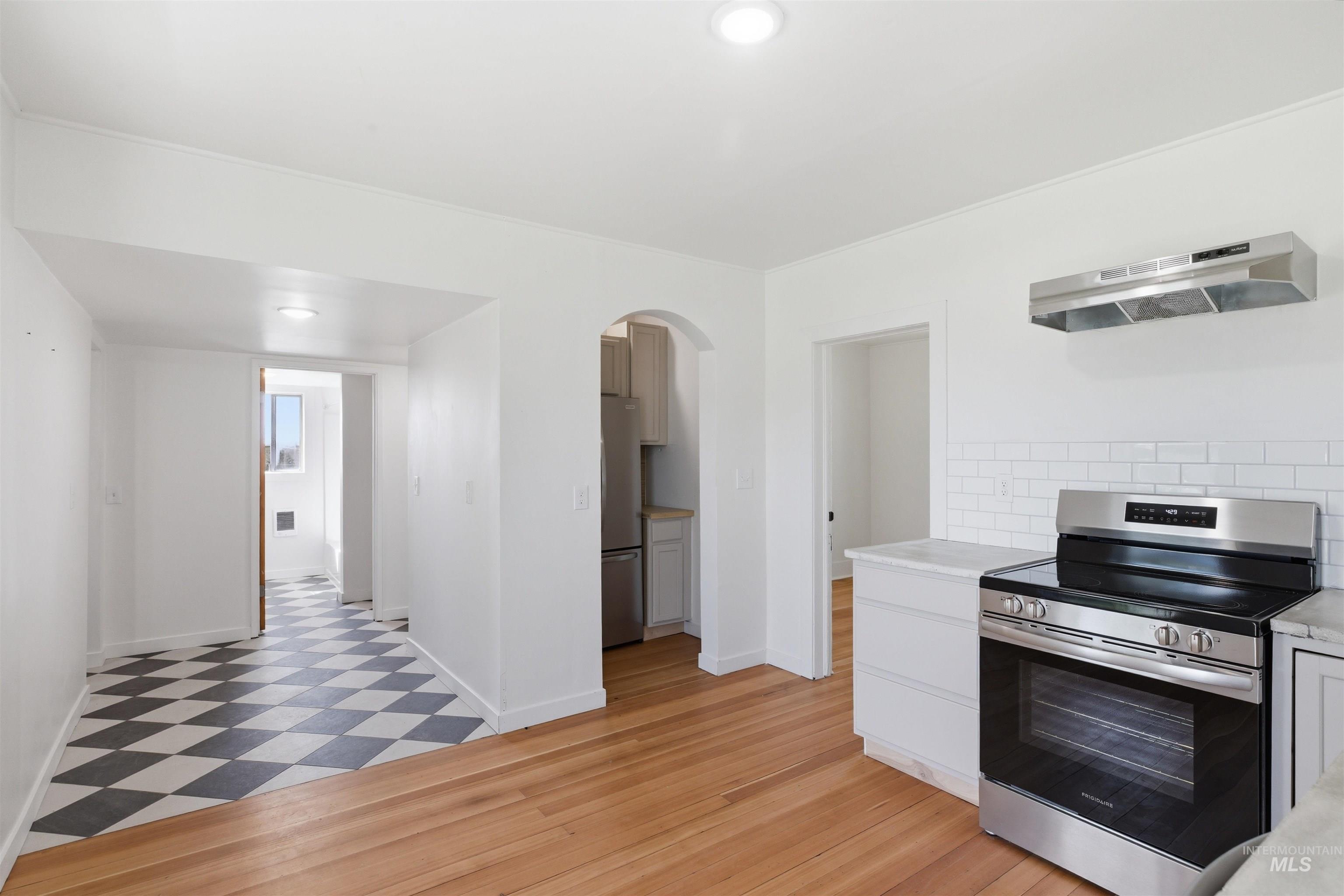 810 Pine Street Potlatch, ID 83855 - Photo 13 of 33 Bright kitchen space featuring wood-finish flooring, stainless steel range, and subway tile backsplash