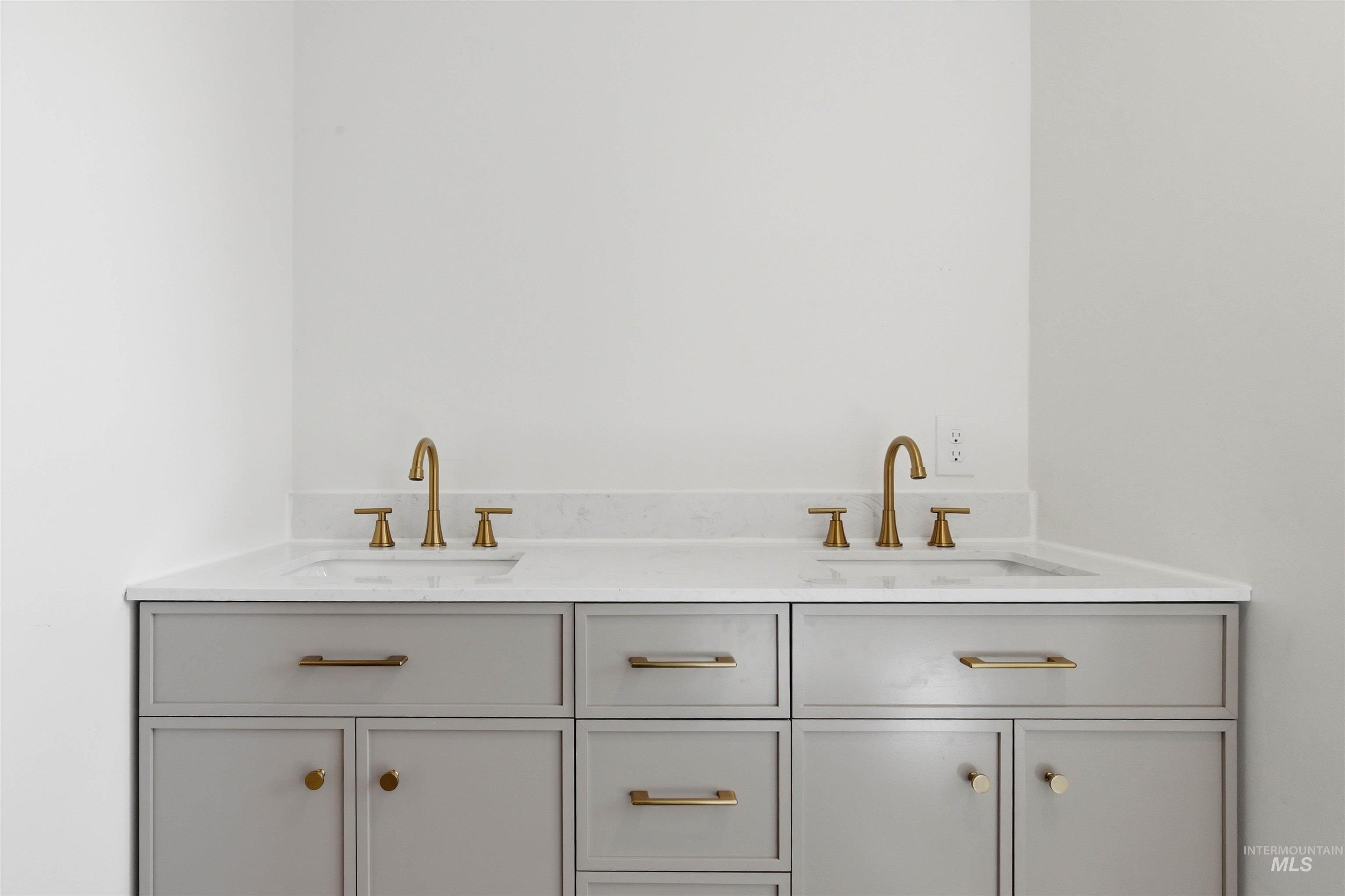 810 Pine Street Potlatch, ID 83855 - Photo 15 of 33 Double vanity with light gray cabinetry, integrated sinks, white countertops, and brass hardware