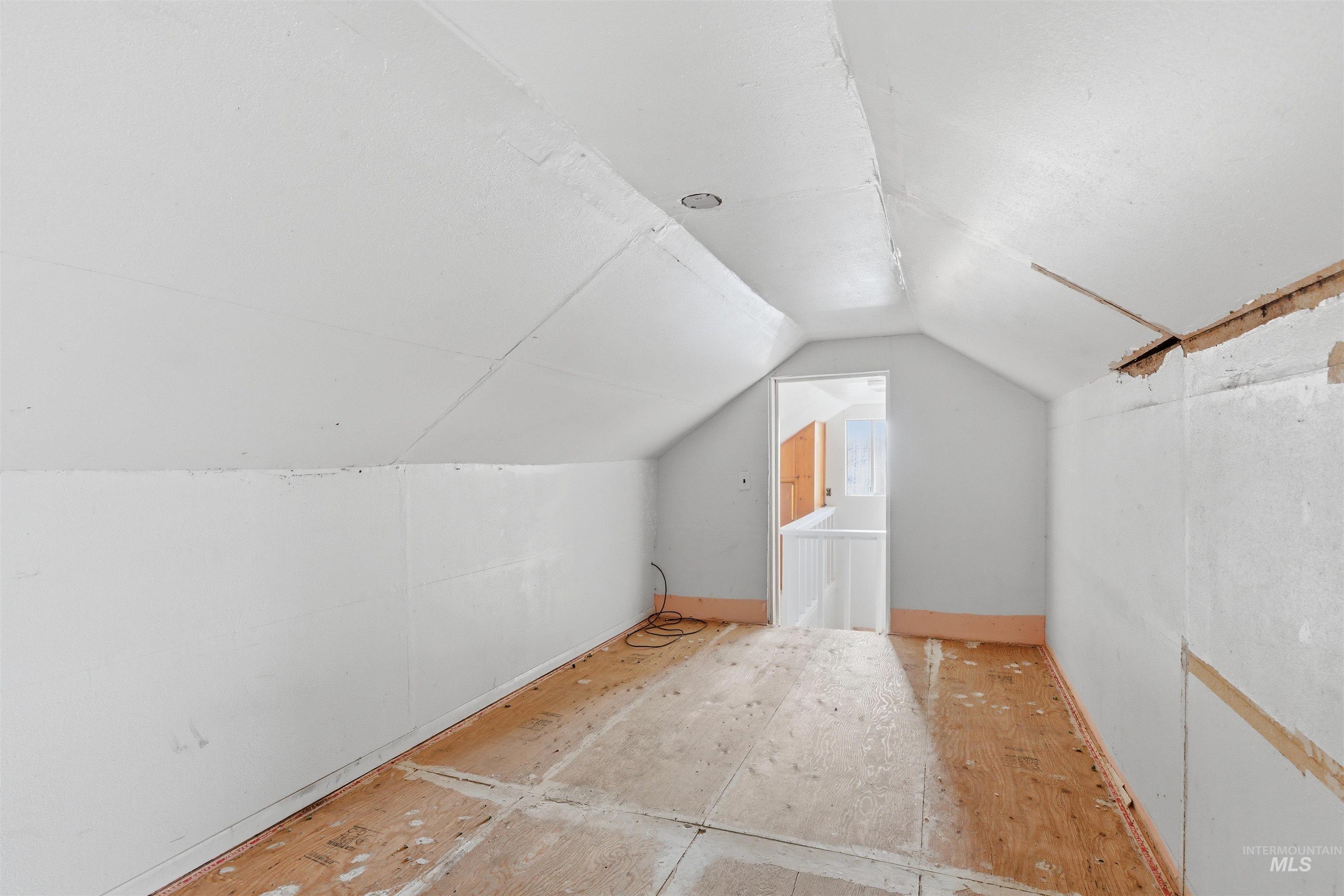 810 Pine Street Potlatch, ID 83855 - Photo 21 of 33 Attic space featuring sloped ceilings, exposed plywood subflooring, and a framed doorway