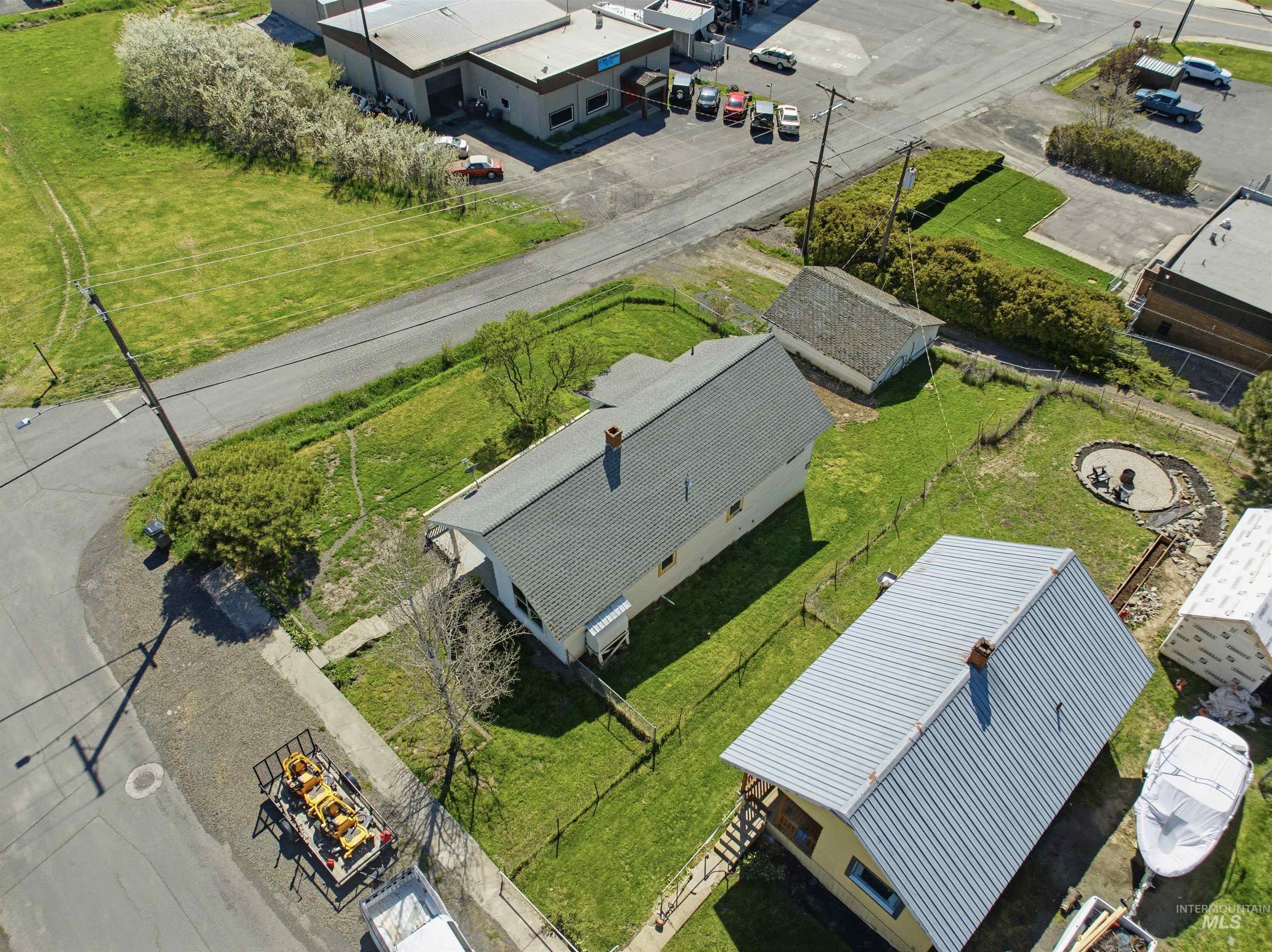 810 Pine Street Potlatch, ID 83855 - Photo 31 of 33 Residential property with two structures, featuring a primary residence with a gray shingle roof and a secondary structure with a corrugated metal roof