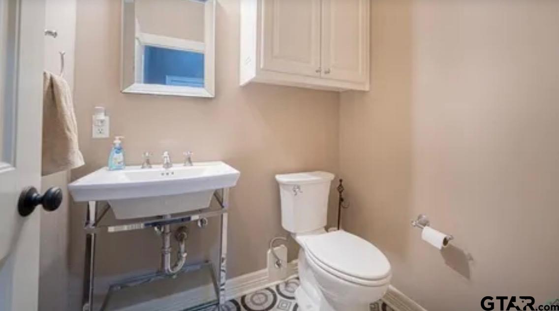 225 Clements Circle Tatum, TX 75691 - Photo 25 of 26 a bathroom with a sink a toilet and mirror