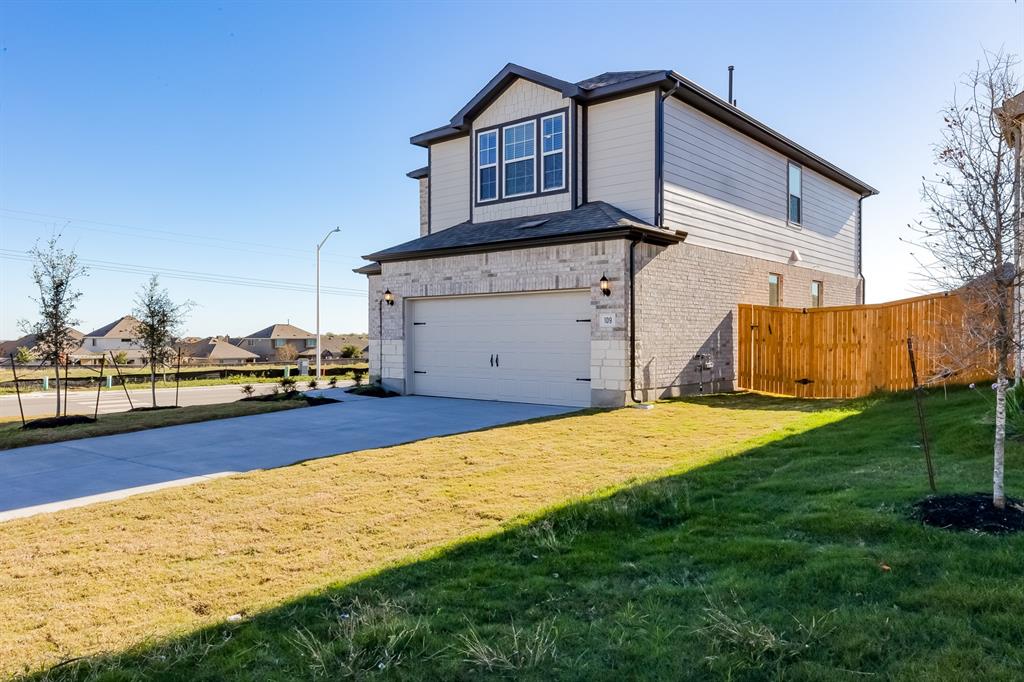 View of side of home with a garage, brick siding, concrete driveway, and a residential view