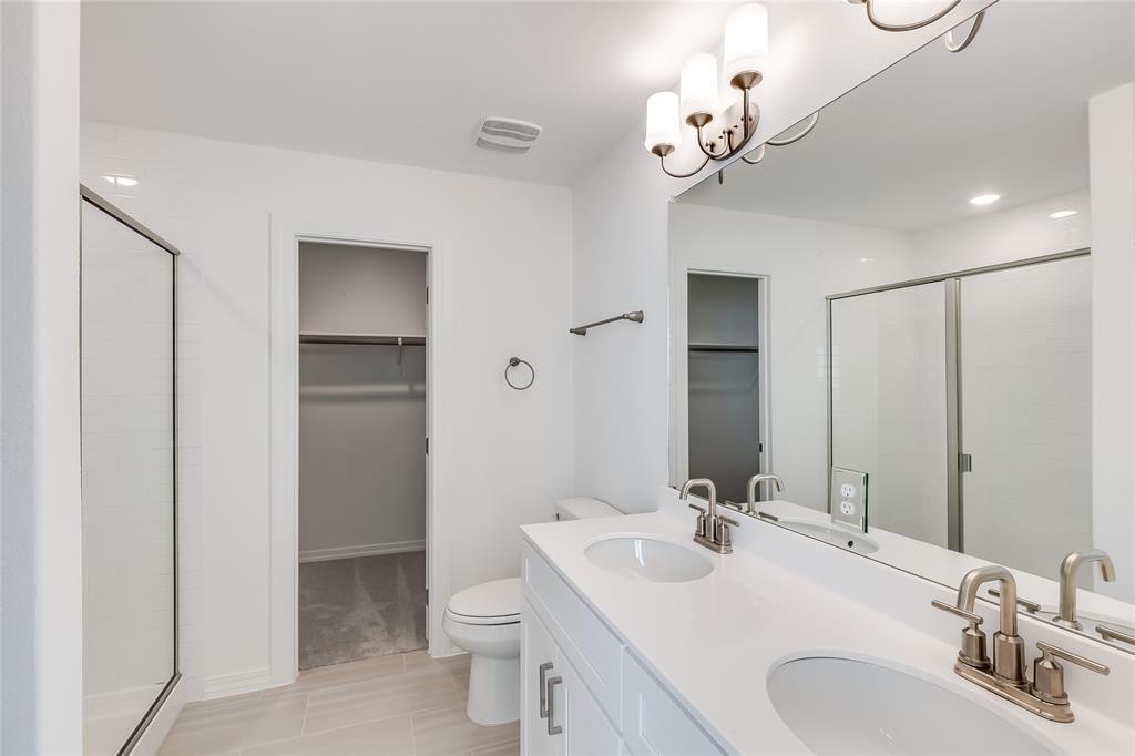 109 Bridge Deck Loop Kyle, TX 78640 - Photo 22 of 40 Bathroom with a spacious closet, double vanity, a shower stall, and a chandelier