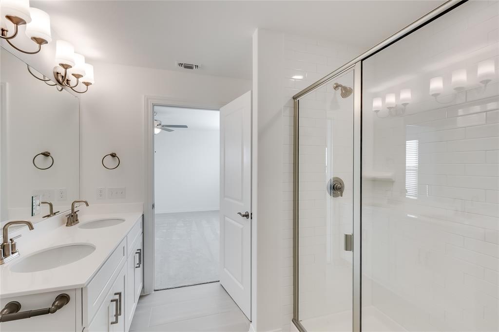 109 Bridge Deck Loop Kyle, TX 78640 - Photo 23 of 40 Full bathroom with double vanity, a stall shower, light tile patterned flooring, and a chandelier