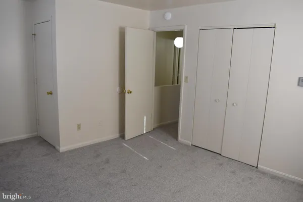 a view of an empty room with closet area