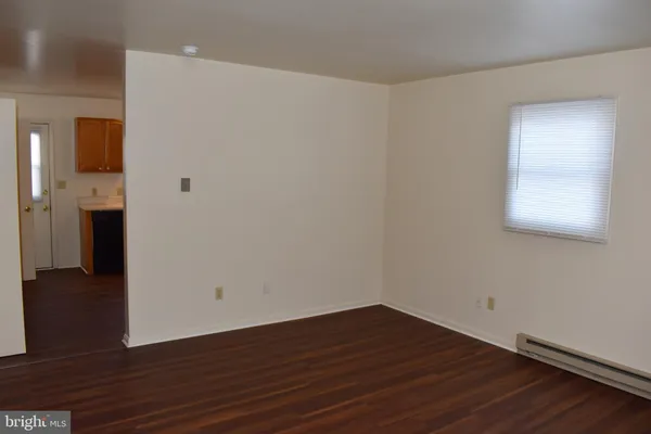 a view of a room with wooden floor and a window