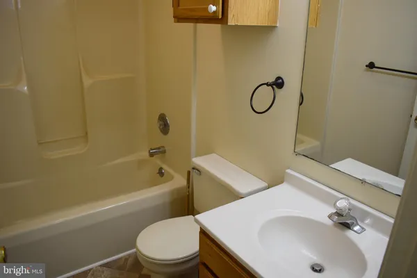 a bathroom with a toilet sink vanity tub and shower