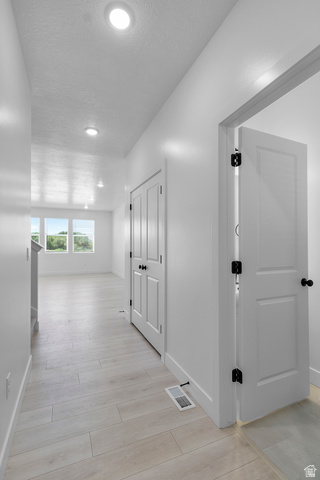 2816 West Aurora Avenue Mapleton, UT 84664 - Photo 2 of 20 Corridor featuring light wood-style floors, recessed lighting, and a textured ceiling