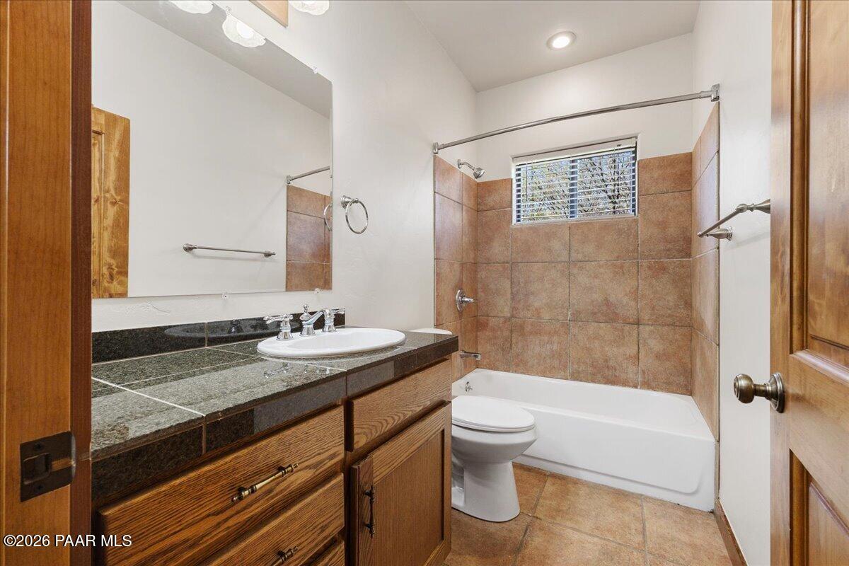 4755 East Lynn Court Lake Montezuma, AZ 86335 - Photo 22 of 36 a bathroom with a granite countertop sink toilet mirror and bathtub