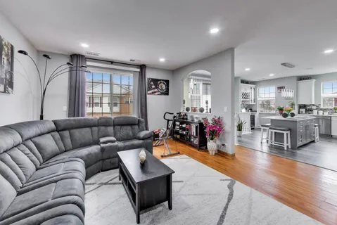 a living room with furniture and a wooden floor