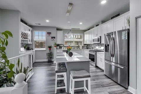 a kitchen with refrigerator a sink and chairs