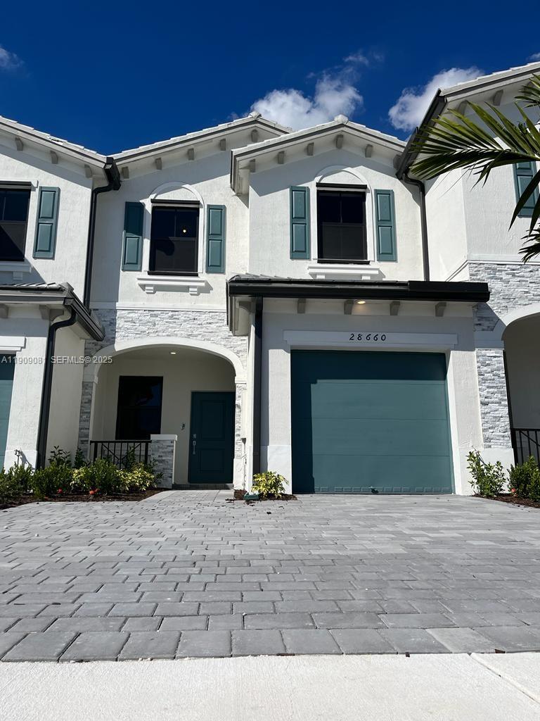 a front view of a house with a yard and garage