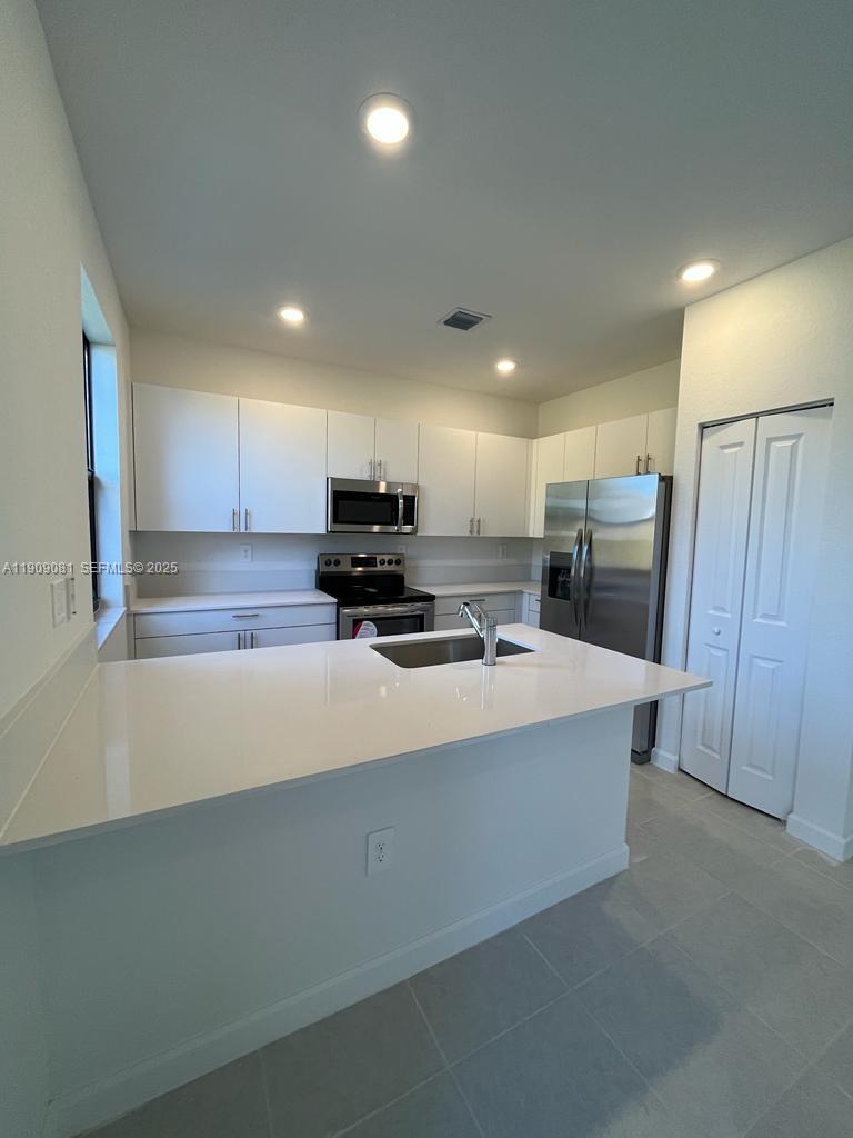 28660 Southwest 134th Court, Unit 28660 Homestead, FL 33033 - Photo 2 of 12 a kitchen with stainless steel appliances a refrigerator sink and microwave