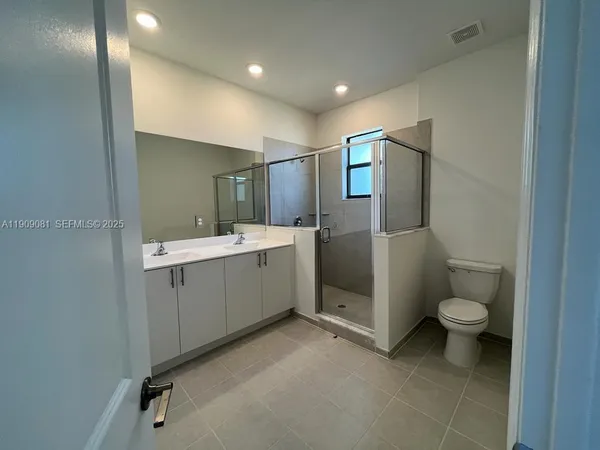 a bathroom with a double vanity sink mirror and shower