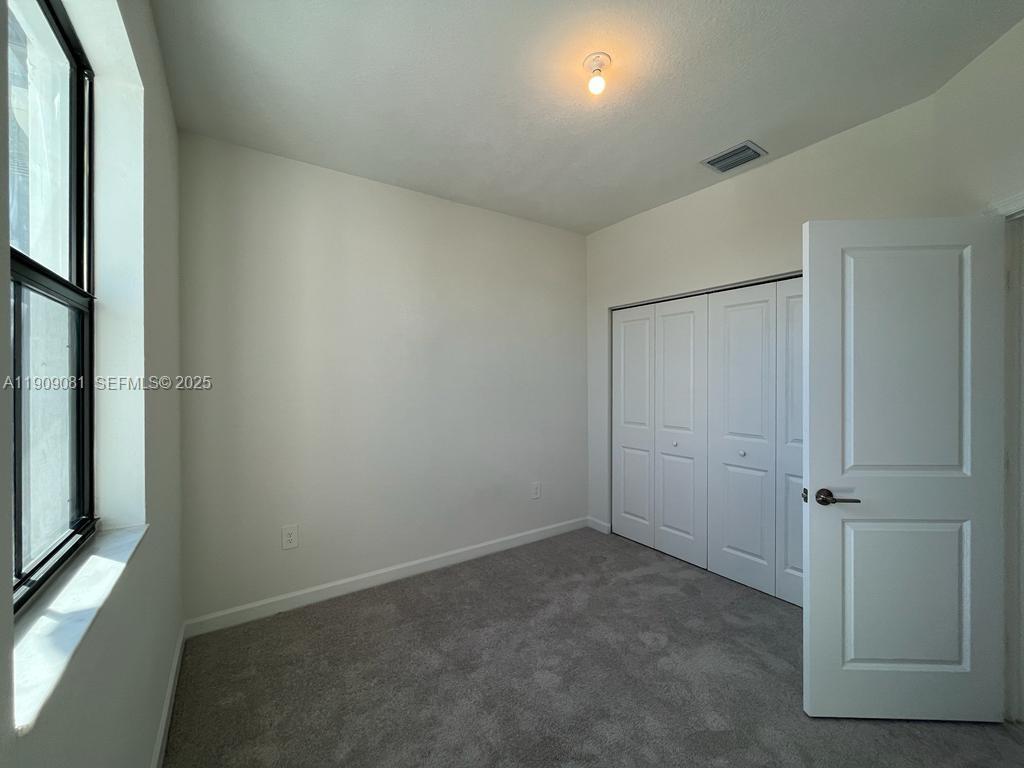 28660 Southwest 134th Court, Unit 28660 Homestead, FL 33033 - Photo 10 of 12 an empty room with windows