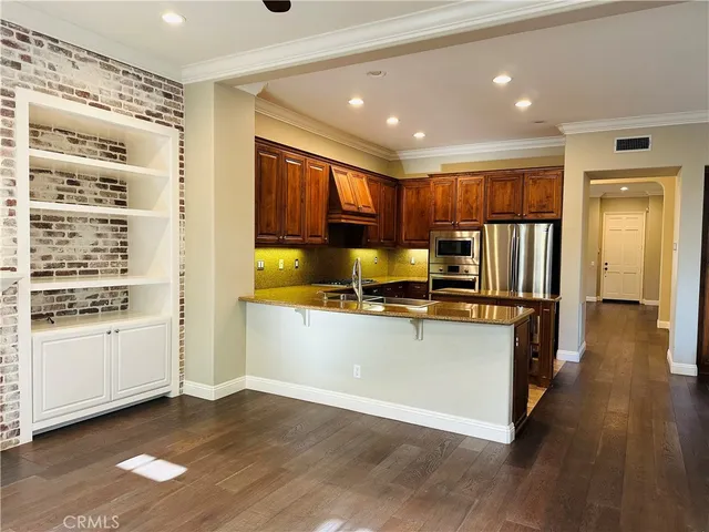 a kitchen with stainless steel appliances granite countertop a refrigerator and a stove top oven