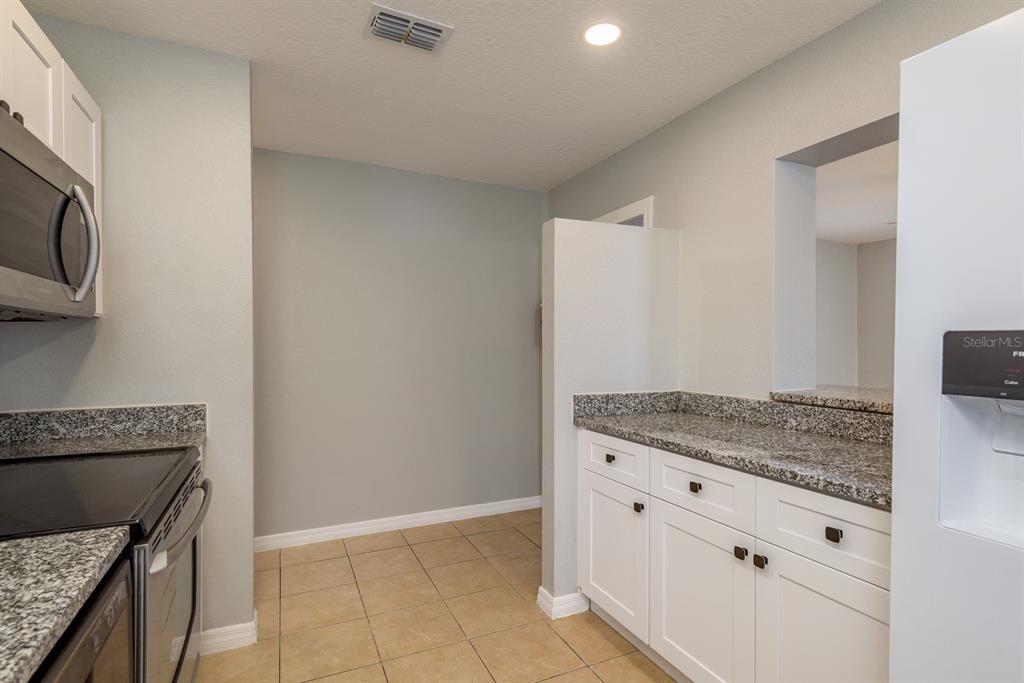 13698 120th Street North Largo, FL 33778 - Photo 11 of 30 a kitchen with granite countertop a stove and a sink