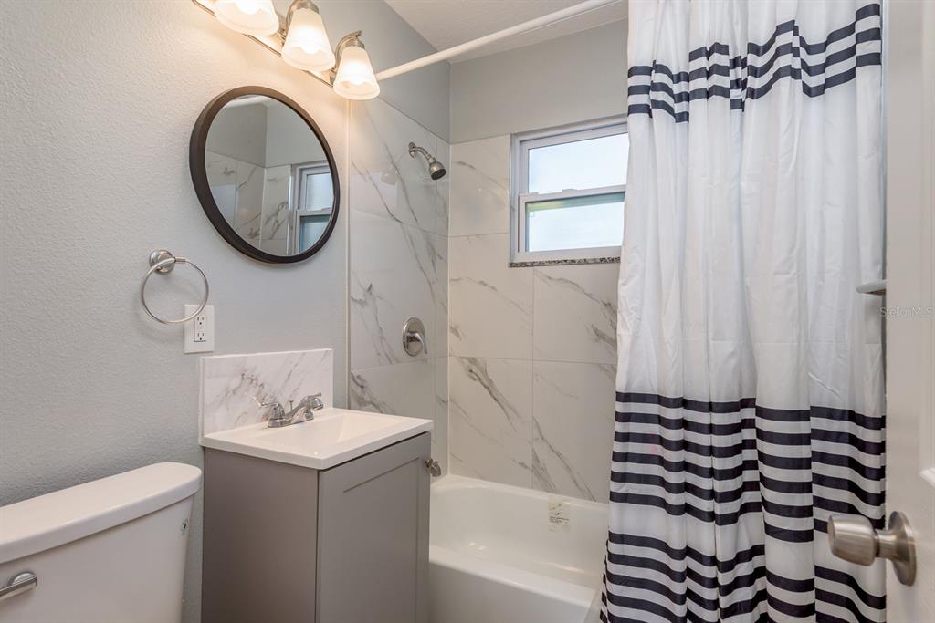13698 120th Street North Largo, FL 33778 - Photo 21 of 30 a bathroom with a sink a toilet and a mirror