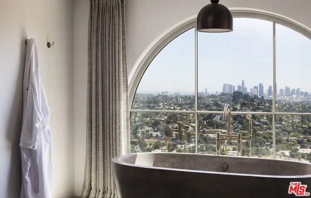 a bathroom with a bathtub a window and a shower