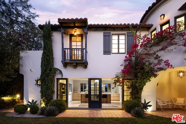a view of a house with a yard and potted plants