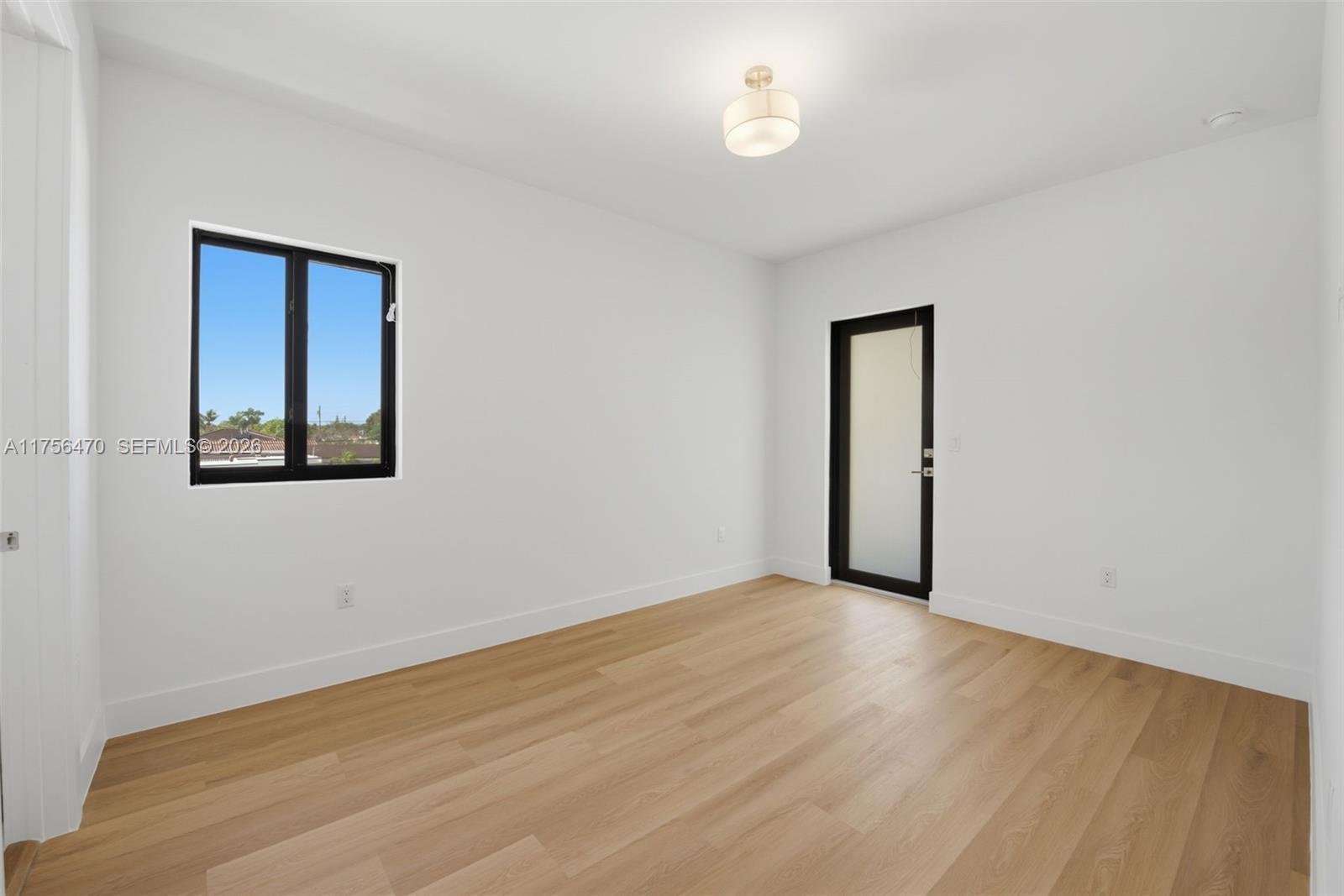 2725 Southwest 65th Avenue Miami, FL 33155 - Photo 16 of 36 an empty room with wooden floor and windows