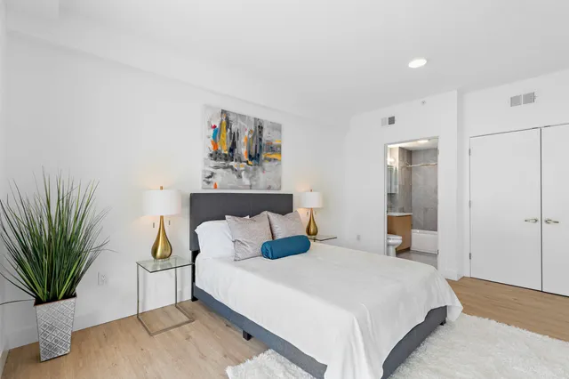 a bedroom with a bed and wooden floor