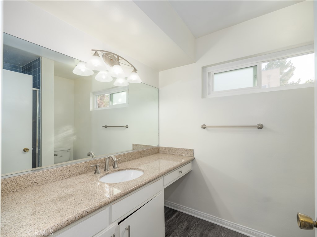 5411 Tyrone Avenue Sherman Oaks, CA 91401 - Photo 22 of 28 a bathroom with a granite countertop sink and a mirror