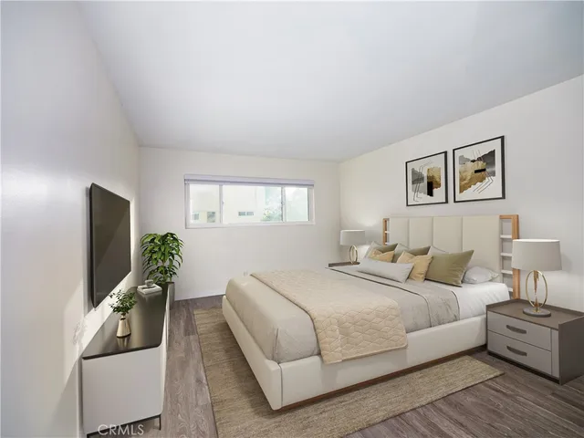 a bedroom with a large bed and a flat screen tv