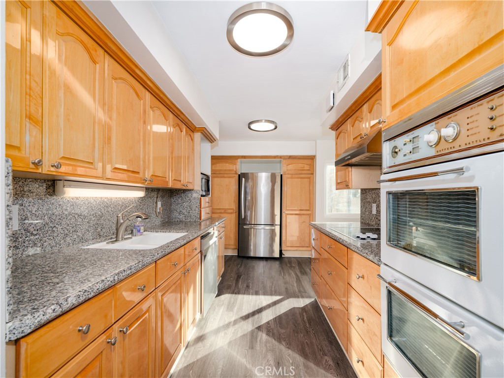 5411 Tyrone Avenue Sherman Oaks, CA 91401 - Photo 10 of 28 a kitchen with granite countertop a sink stove and cabinets