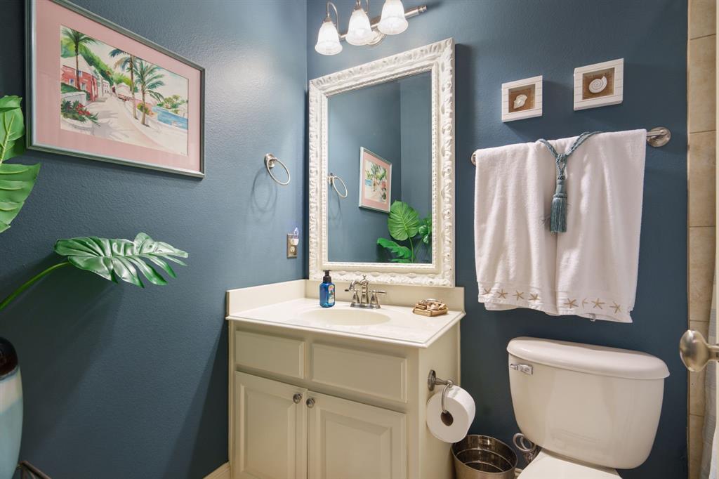 9144 Calvert Road Lantana, TX 76226 - Photo 12 of 40 a bathroom with a toilet a sink and mirror