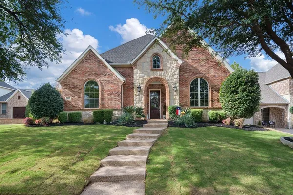 a front view of a house with a garden and yard