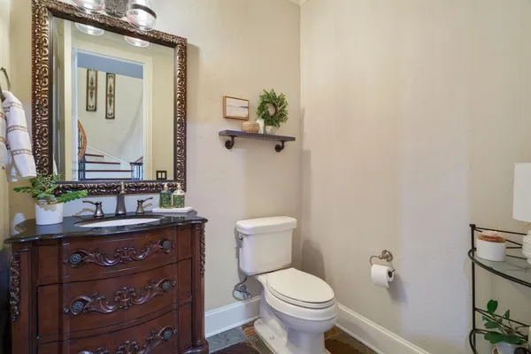 a bathroom with a toilet a sink and mirror