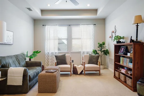 a living room with furniture and a book shelf