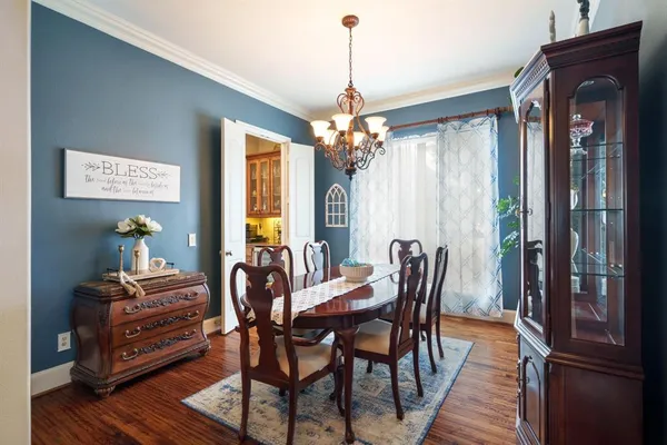a dining room with furniture a chandelier and wooden floor