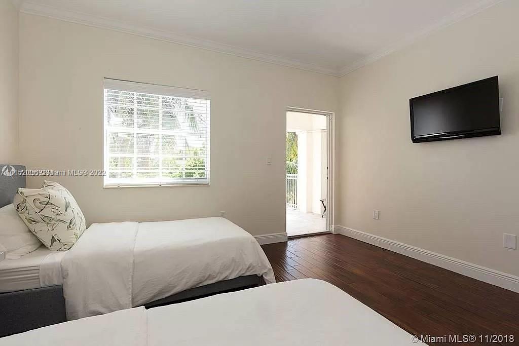 272 Fernwood Road Key Biscayne, FL 33149 - Photo 15 of 30 a bedroom with a bed and a flat screen tv