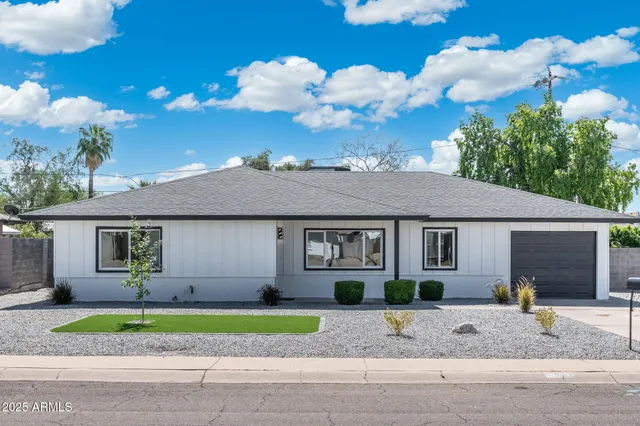 a view of a white house next to a yard