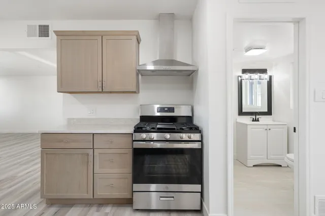a kitchen with granite countertop a stove a sink and a refrigerator