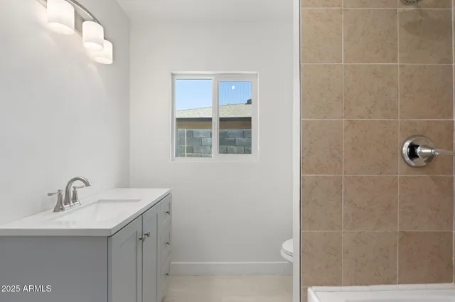 a bath tub sitting next to a white toilet and a shower