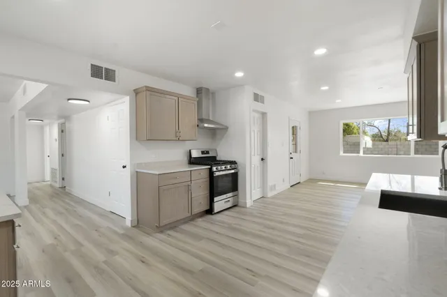 a kitchen with granite countertop a sink stove and refrigerator