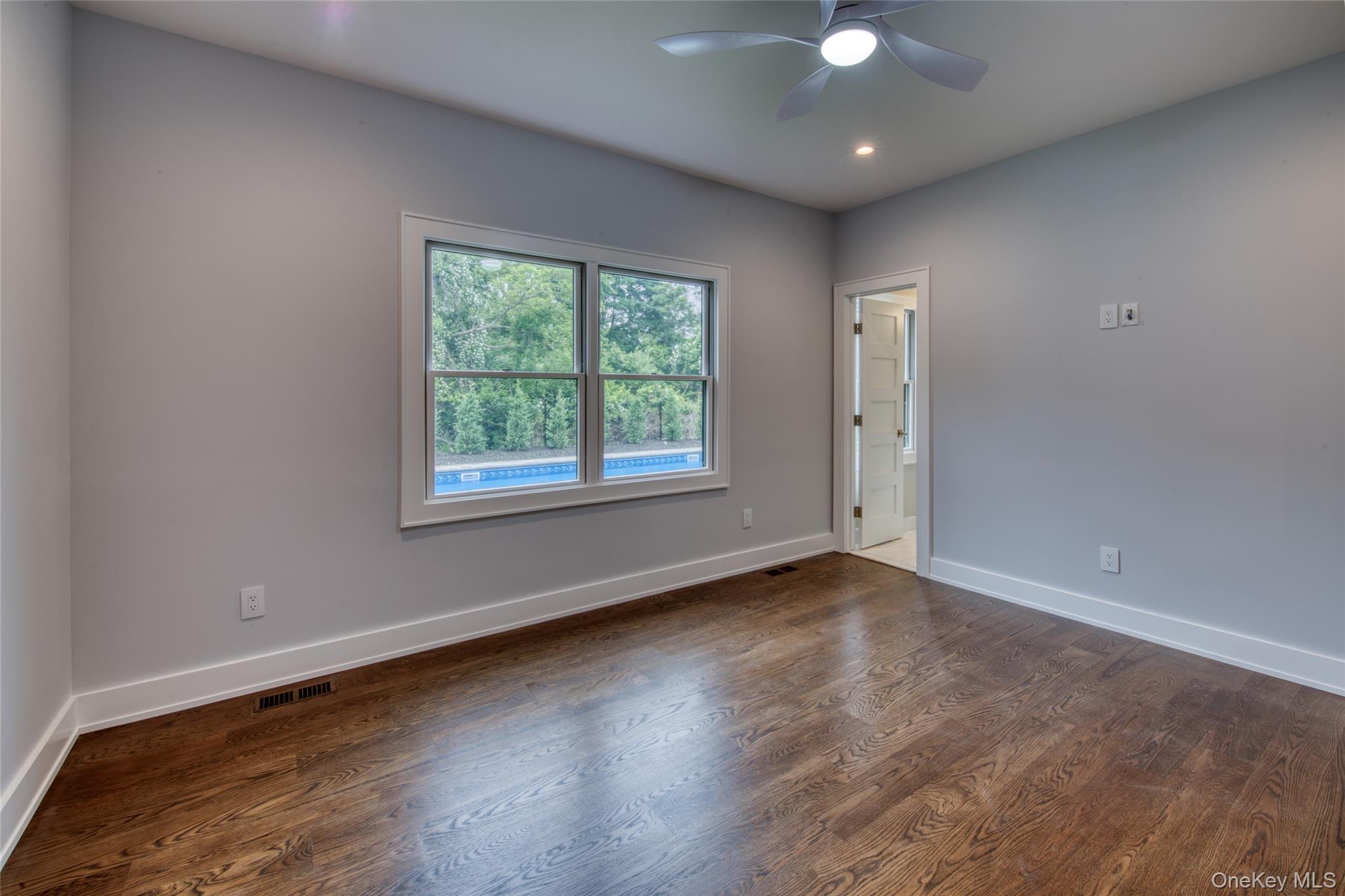 435 Maple Lane Greenport, NY 11944 - Photo 19 of 44 an empty room with wooden floor and windows