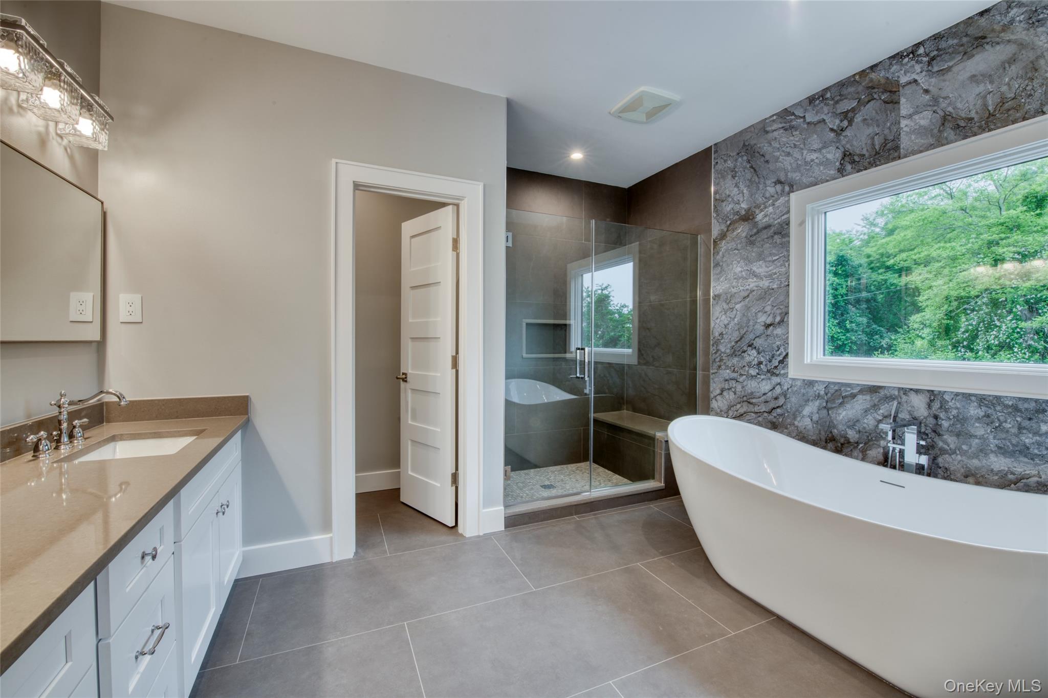 435 Maple Lane Greenport, NY 11944 - Photo 27 of 44 a bathroom with a tub a sink and a large mirror