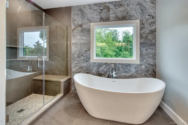 a white bath tub sitting in a bathroom next to a window