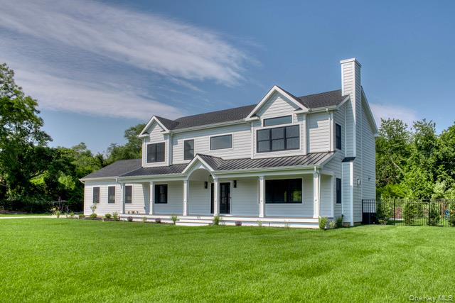 435 Maple Lane Greenport, NY 11944 - Photo 38 of 42 View of front of property featuring covered porch, a chimney, a metal roof, and a standing seam roof